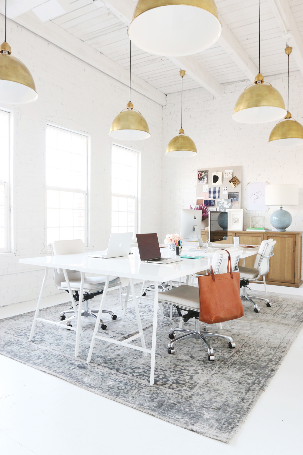 large white office space with gold pendant lights 