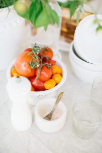 tomatoes in strainer, dish of salt and pepper