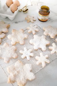 snowflake cookies on cooling rack dusted with icing sugar