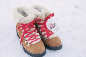 Boots in snow with red laces and gift tag attached