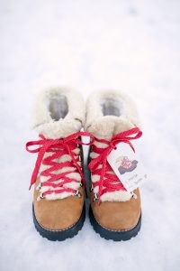 boots in snow with red laces and gift tag