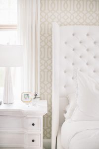 white tufted headboard, neutral wallpaper, bedside table