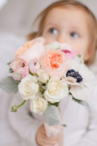 little girl holding bouquet of flowers