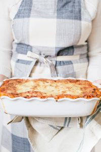 women holding lasagna