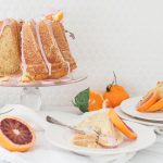 citrus bundt cake on cake stand with sliced cake on plates
