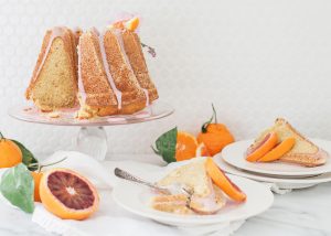 citrus bundt cake on cake stand with sliced cake on plates