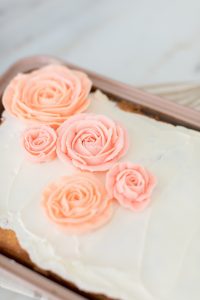 pink buttercream rose on white icing