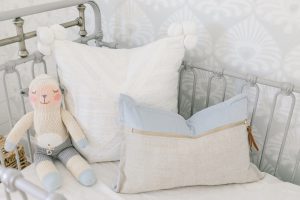 grey and blue pillows in metal crib