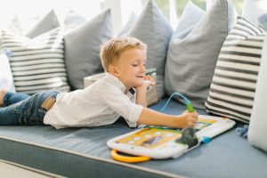 boy playing with learning tool on window seat