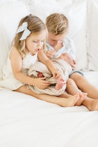 brother and sister holding baby brother
