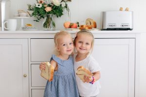 two little girls hugging with toast in their hands