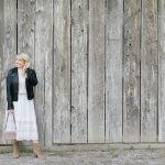 women by barn in white dress and leather jacket
