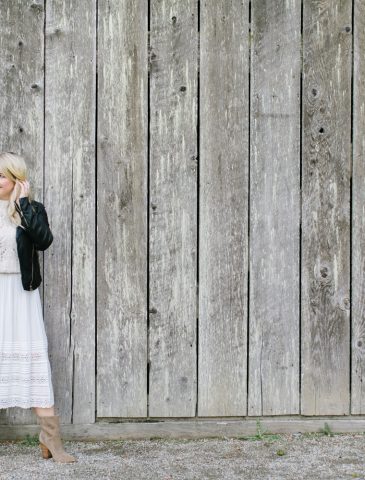 women by barn in white dress and leather jacket