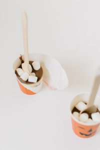 white cocoa spoons in pumpkin cups