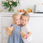 two little girls hugging with toast in their hands