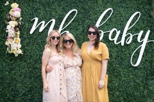 women in front of boxwood wall for baby shower