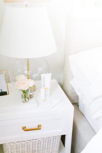 night stand with flowers and face products