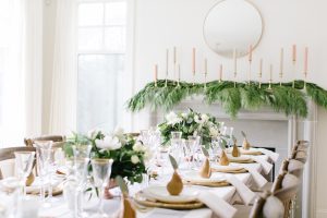 table setting with golden pears, garlands, pink and white candles