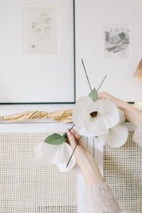 white paper magnolia flowers attaching to garland base