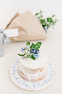 mini naked iced vanilla cake with blue florals and blueberries