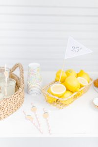 tabletop with 25 cent flag in a basket of lemons