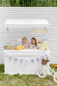 two young girls two young girls behind a lemonade booth