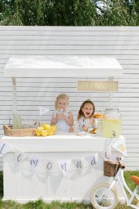 two young girls two young girls behind a lemonade booth