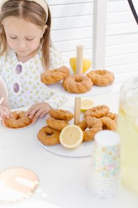 donuts & lemons on a table with a young girl eating
