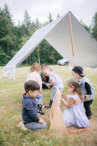 kids playing connect four with a striped tent in the back