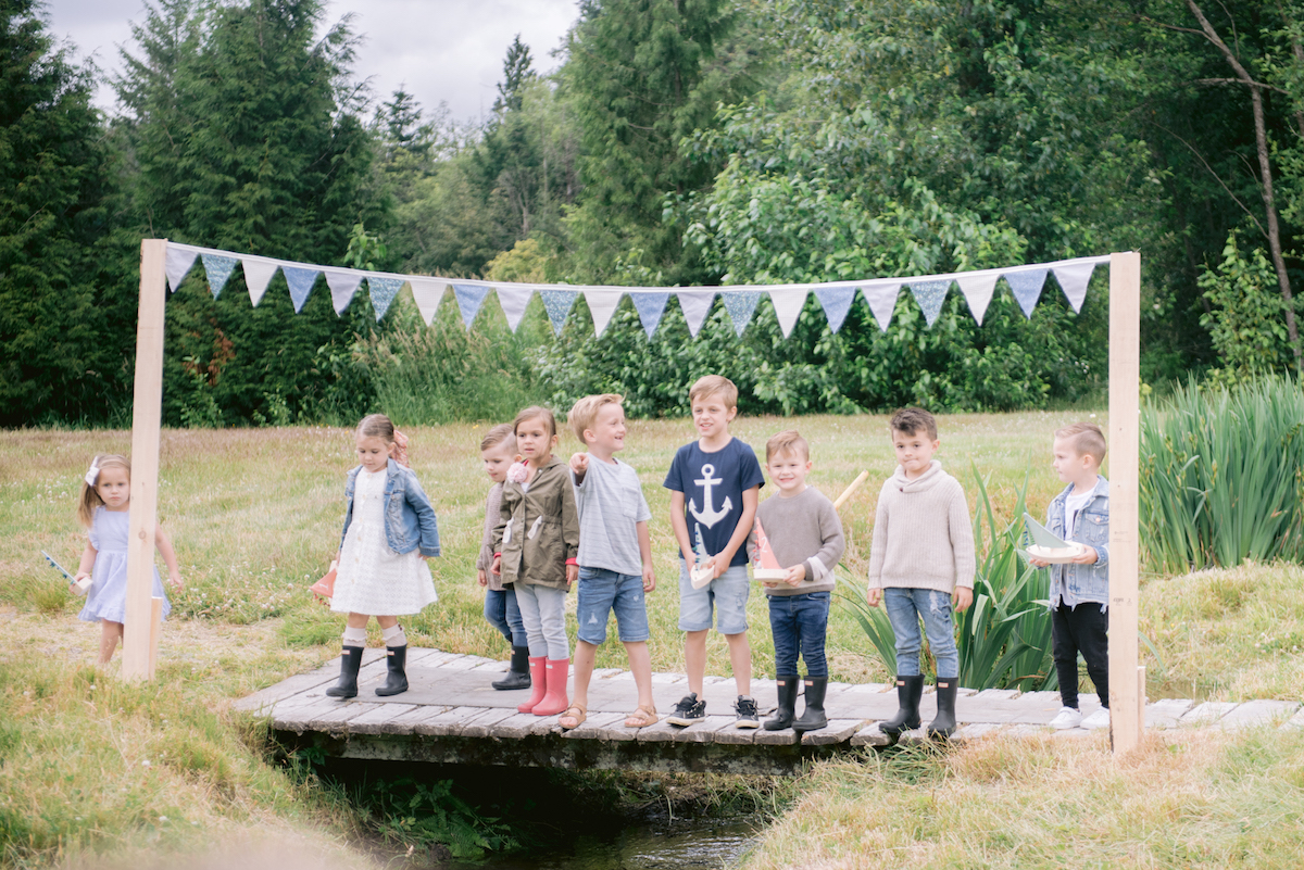 kids lining up on a bridge for toy boat racing