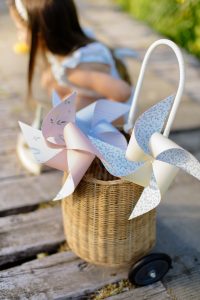 Pinwheels in a basket in front of a girl sitting